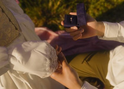 Vintage-inspired outdoor proposal with engagement ring and romantic atmosphere.